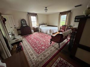 埃爾金斯的住宿－Upstairs Historic 1 Bedroom 1 Bath Suite with Mini-Kitchen, Porch & River Views，一间卧室配有一张床和红色地毯