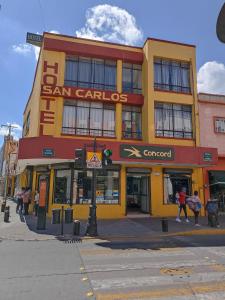 ein gelbes und rotes Gebäude in einer Stadtstraße in der Unterkunft Hotel San Carlos in Irapuato