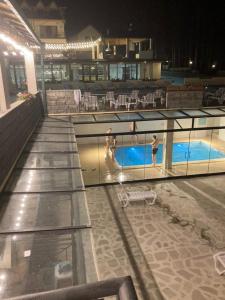 two people in a swimming pool at night at Hotel Surami in Surami