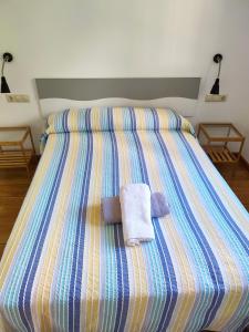 a bed with two towels on top of it at Casa turística a Ardiña in Caldas de Reis