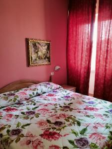 a bedroom with a bed with a floral bedspread at Il Centrale in Cortona