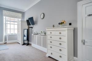 a bedroom with a dresser and a clock on the wall at Wakefield Town House in Wakefield