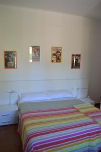 a bed in a bedroom with three pictures on the wall at Agriturismo Le Forre del Treja (La Villa) in Civita Castellana