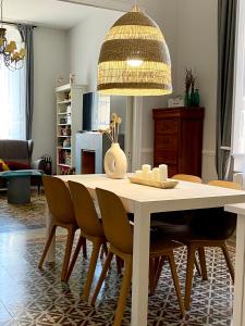 une table à manger avec des chaises et un lustre dans l'établissement Casa en Palafrugell - Costa Brava, à Palafrugell