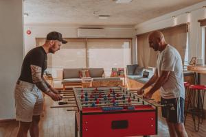 two men standing in a living room playing with a foosball at Nomads Hotel in Wadi Musa