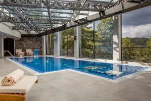 a swimming pool in a house with a large window at Panorama Hotel & Spa in Kruševo