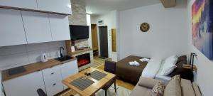 a living room with a couch and a table at Apartmani MONTES Jahorina in Jahorina