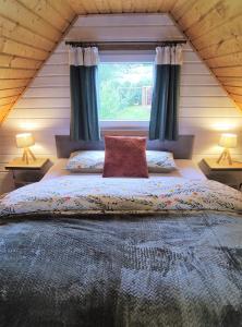a bedroom with a large bed with a window at Domek BB in Podgórzyn