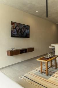 un soggiorno con TV a parete di Private pool and rooftop for 3 a Tulum