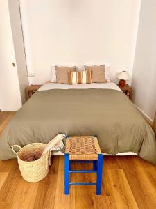 ein Schlafzimmer mit einem Bett mit einem Stuhl und einem Korb in der Unterkunft ADI BOUTIQUE HOUSE in Thessaloniki