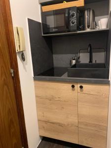 a kitchen with a sink and a microwave at Georges Sand in Châtenay-Malabry