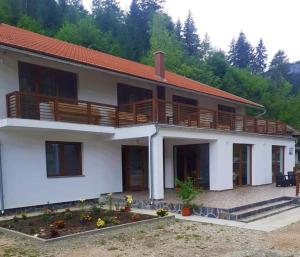 a large white house with wooden balconies on it at Pensiunea Cheile Șugăului in Bicaz Chei