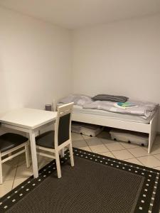 Zimmer mit einem Bett, einem Tisch und einem Stuhl in der Unterkunft FeWo Bruni II in Oldenburg