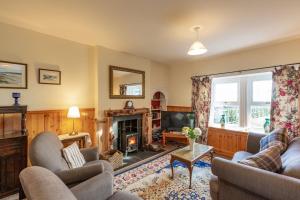 a living room with a fireplace and a tv at Chapelton Cottage No 2 in Kirkcudbright