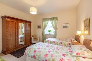 a bedroom with two beds and a window at Chapelton Cottage No 2 in Kirkcudbright