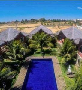 an aerial view of a house with a blue pool at Canoappart in Canoa Quebrada