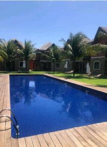 a large blue swimming pool in front of a house at Canoappart in Canoa Quebrada