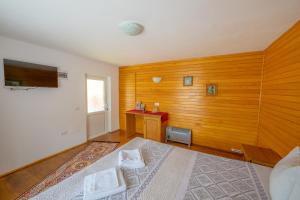 1 dormitorio con 1 cama y pared de madera en Cabana TYF Dreptu - TYFTRAVEL SRL, en Poiana Teiului