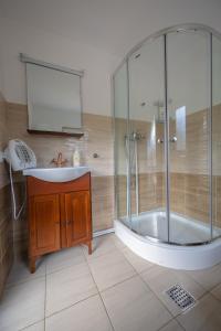 a bathroom with a tub and a sink and a shower at Cabana TYF Dreptu - TYFTRAVEL SRL in Poiana Teiului