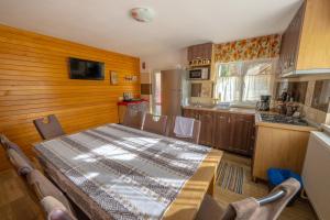 a kitchen with a table and a kitchen with a refrigerator at Cabana TYF - Dreptu in Poiana Teiului