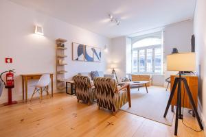 リスボンにあるModern Rustic Flat in Santos by LovelyStayのテーブルと椅子のあるリビングルーム