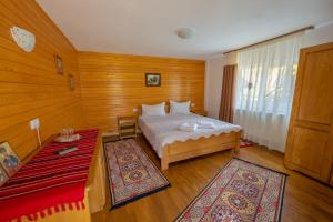 1 dormitorio con cama y alfombra roja en Cabana TYF Dreptu - TYFTRAVEL SRL, en Poiana Teiului