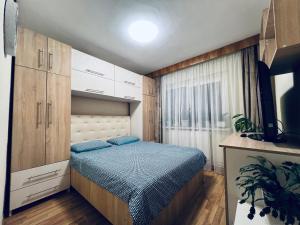 Habitación pequeña con cama y ventana en Altheda Living Tineretului E8 en Suceava