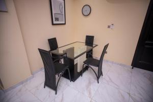 mesa de comedor con sillas negras y reloj en la pared en 2Bed Apartment Sleeps 4 - Parking Wifi, en Accra 34 fotos más