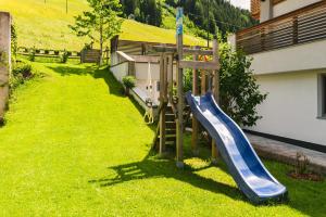 a playground with a slide in a yard at Haus Sabrina - Ferienwohnungen in Saalbach Hinterglemm
