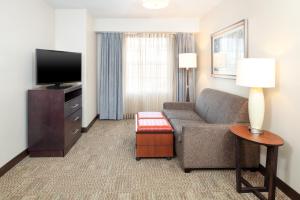 a living room with a couch and a flat screen tv at Staybridge Suites Denver - Central Park, an IHG Hotel in Denver