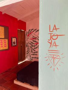 una habitación con una pared roja y una cama en ella en Casa de Campo - Hotel Desayuno Pizza Bar en Medellín
