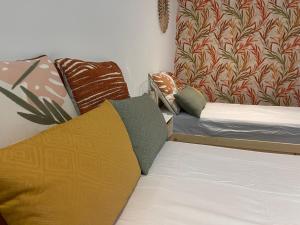 ein Zimmer mit 2 Betten mit Kissen darauf in der Unterkunft La maison du manoir 1900 une expérience en famille in La Ferté-Gaucher