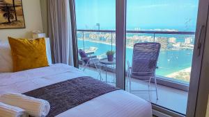 a bedroom with a bed and a balcony with a view at Exquisite, luxe 1BD Apartment, Unparalleled Sea Views, Prime Dubai Marina Location & Full Kitchen by "La Buena Vida Holiday Homes in Dubai