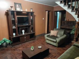 - un salon avec un fauteuil et une télévision dans l'établissement Casa Navarra, à Lima