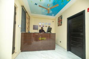 una mujer sentada en una recepción en una habitación en 2Bed Apartment Sleeps 4 - Parking Wifi, en Accra