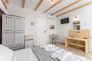 biała sypialnia z łóżkiem i umywalką w obiekcie Agios Prokopios Hotel w miejscowości Agios Prokopios