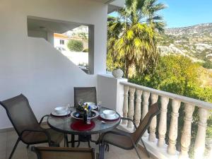 a dining room with a table and chairs on a balcony at Peyia Resort Apartment in Peyia