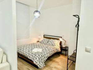 um quarto branco com uma cama e um candeeiro em China Town Madrid 02 em Madri
