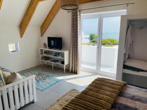 a room with a crib and a television and a balcony at CVista in Jacobs Bay