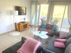 a living room with a couch and a table at Peyia Resort Apartment in Peyia