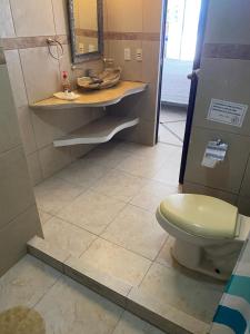 a bathroom with a toilet and a sink and a mirror at Gran habitacion con terraza vista espectacular, piscina in Acapulco +23 photos