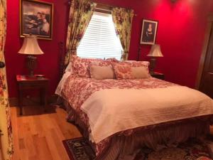 Schlafzimmer mit einem Bett mit roten Wänden und einem Fenster in der Unterkunft The Destination B&B llc in Salem