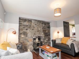 een woonkamer met een stenen muur en een open haard bij 2 Seafield Place in Portsoy