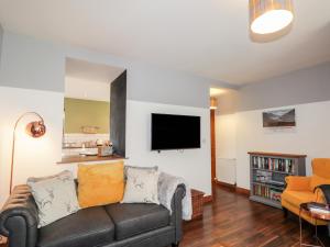 een woonkamer met een bank en een flatscreen-tv bij 2 Seafield Place in Portsoy
