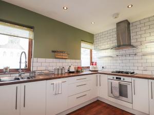 a kitchen with white cabinets and a sink at 2 Seafield Place in Portsoy