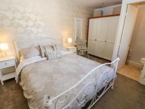 a bedroom with a white bed and a white cabinet at Prospect Cottage in Sowerby Bridge