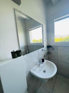Baño blanco con lavabo y espejo en B&B Le Albare, en Montecchia di Crosara