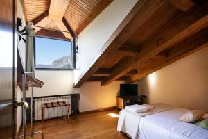 Schlafzimmer mit einem großen Fenster und einem Bett in der Unterkunft La Casona de Alesga, Asturias-Fresnedo in Fresnedo