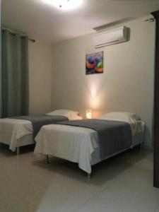 a room with two beds and a air conditioner at Andira Apartments in Willemstad