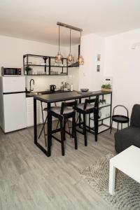 una cucina e una sala da pranzo con tavolo e sedie di Apartman Ina a Osijek